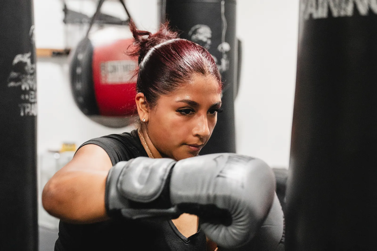 Boxer working a heavy bag in the T Mack Elite Training area at Hidden Gym Allen