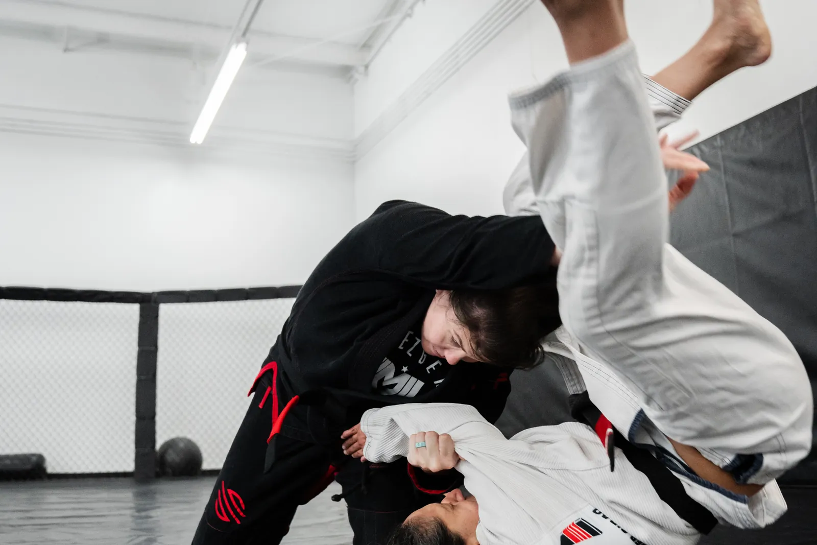 Two jiu-jitsu students in gis working a guard pass on the mats at Hidden Gym Richardson