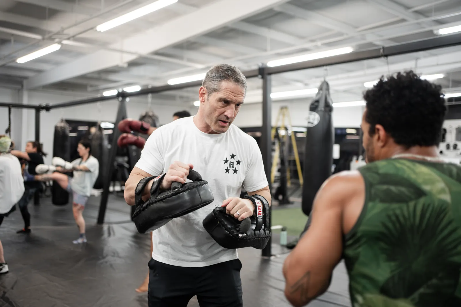 Guy Mezger holding focus mitts for a student during a private lesson