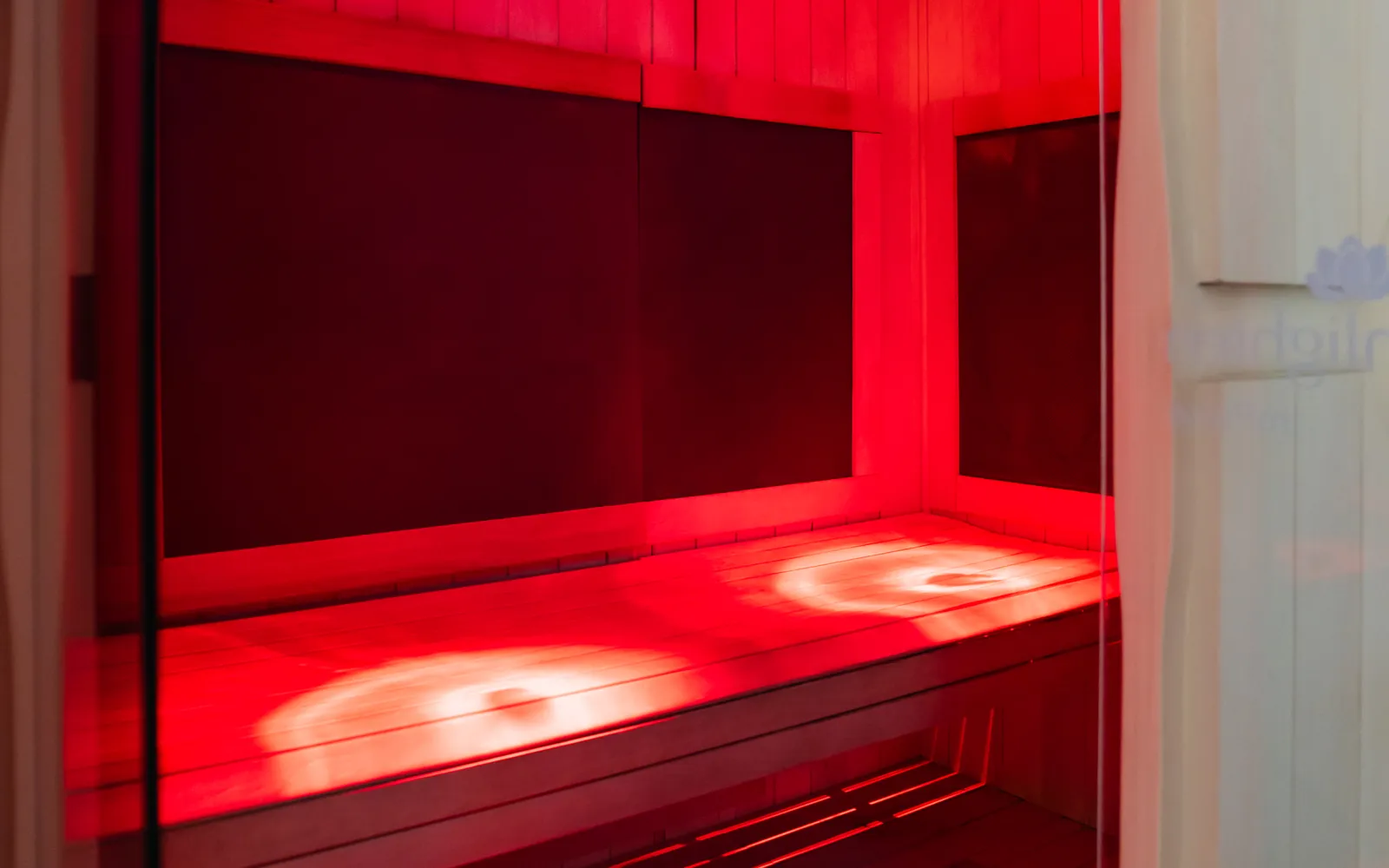 Infrared sauna glowing inside the recovery area at Hidden Gym North Dallas