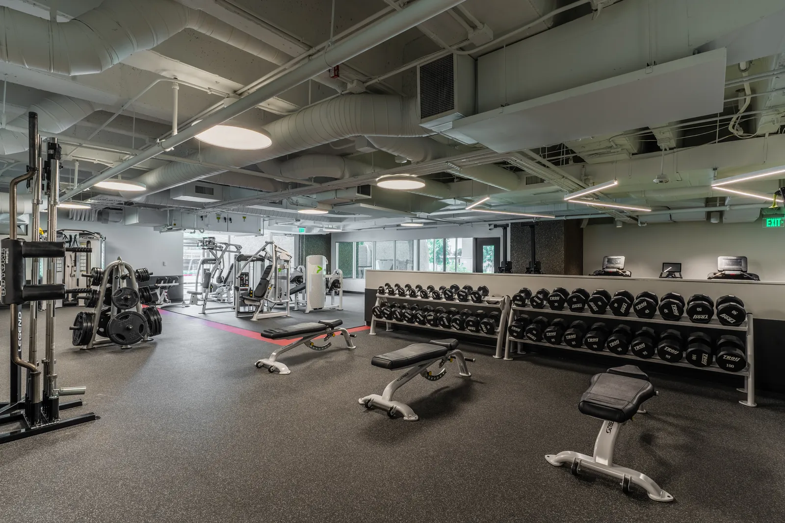 Dumbbell and bench area inside Hidden Gym at Pegasus Park, Dallas